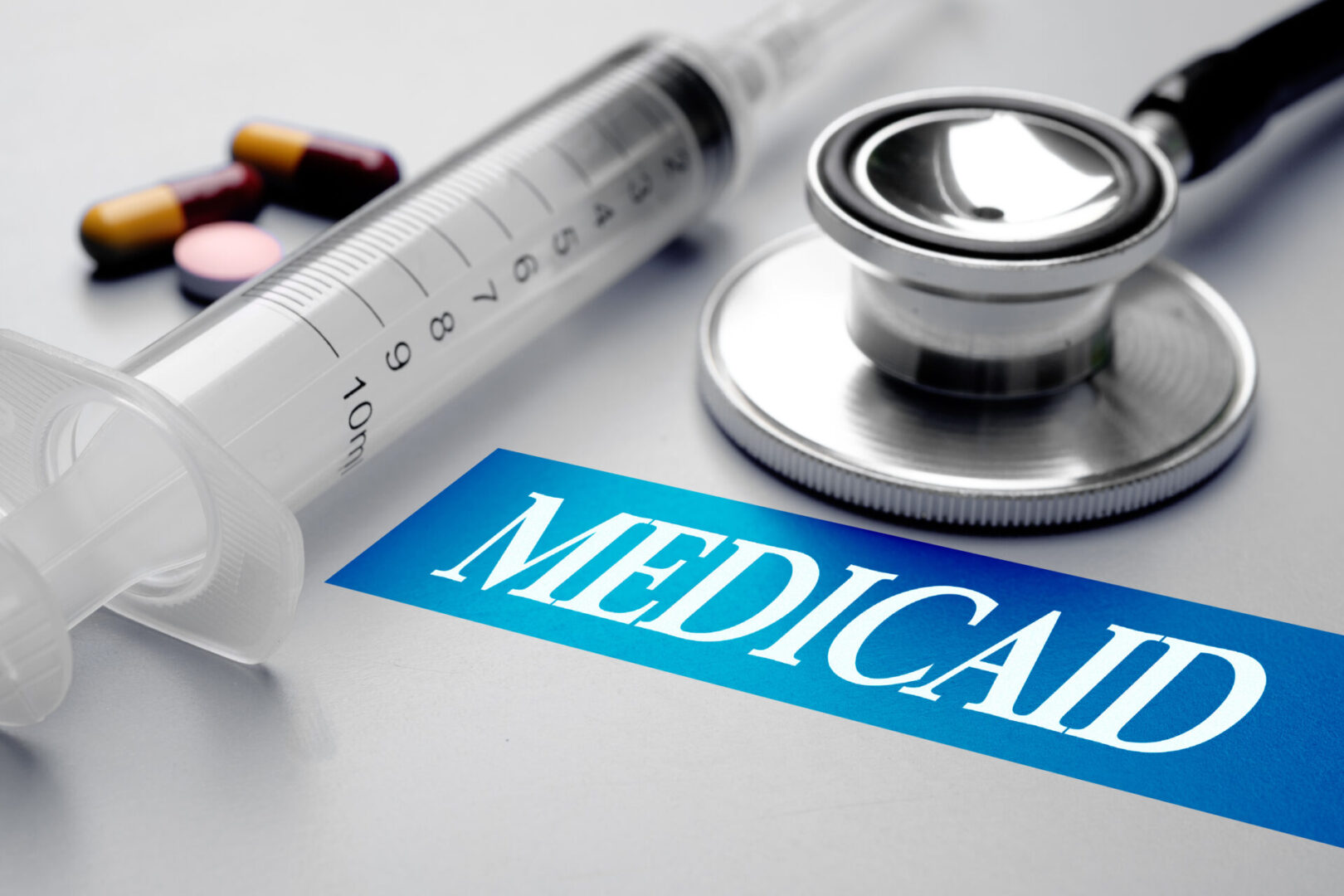 Medicaid,,Health,Concept.,Stethoscope,,Syringe,And,Pills,On,Grey,Background.