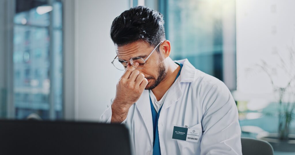 Doctor rubbing his eyes from fatigue