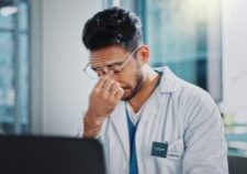 Doctor,,Man,And,Tired,With,Headache,By,Laptop,,Anxiety,And