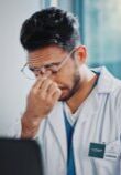 Doctor rubbing his eyes from fatigue